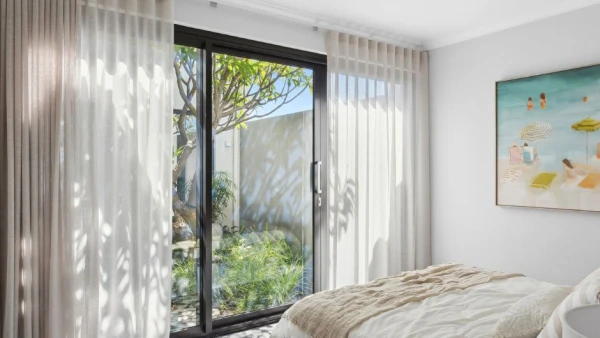Sliding door in bedroom with sheer curtains