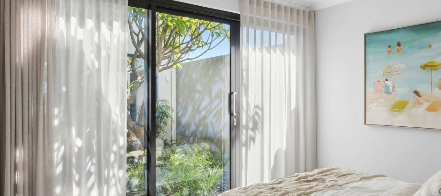 Sliding door in bedroom with sheer curtains