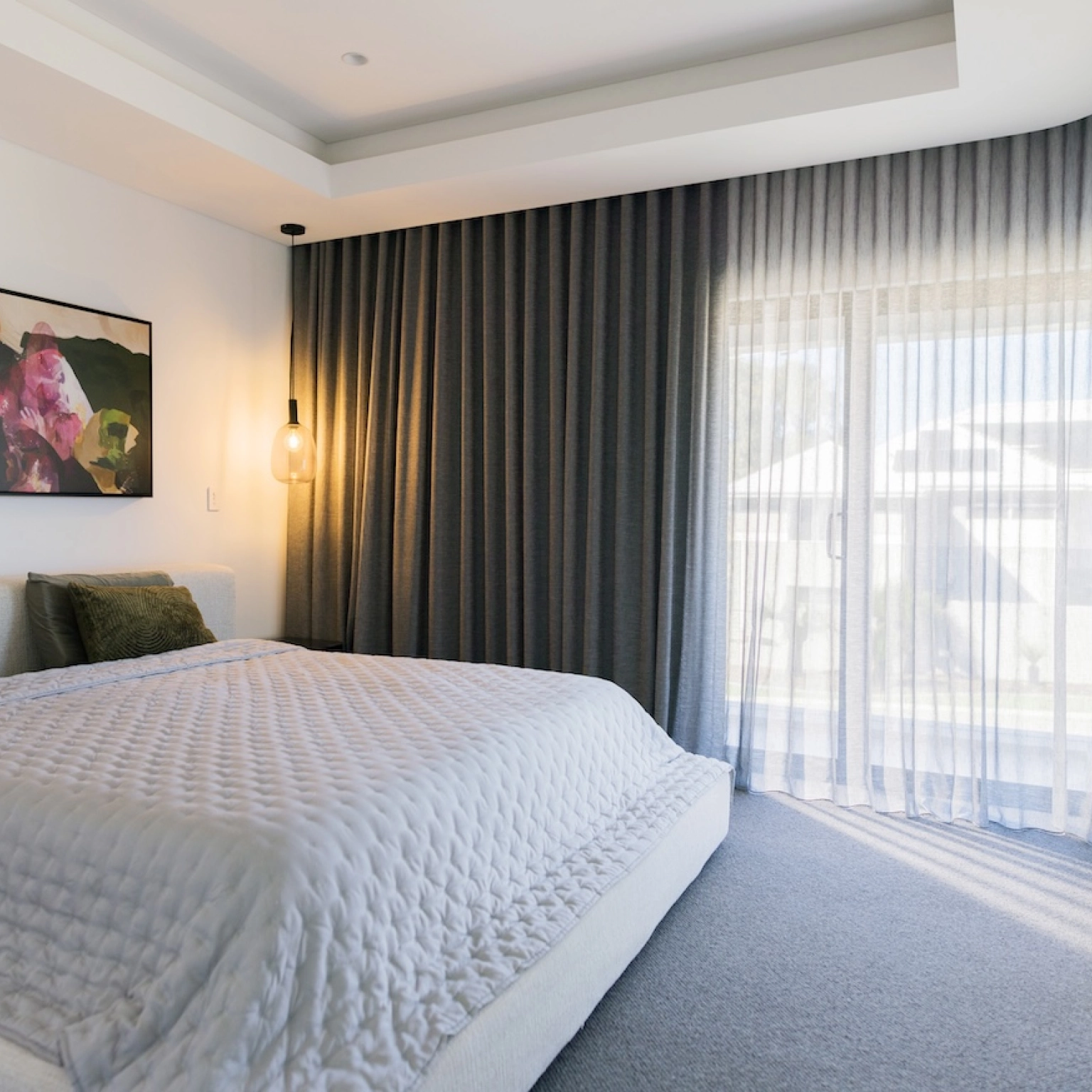 Layered blockout curtains and sheers in a drak fabric in bedroom
