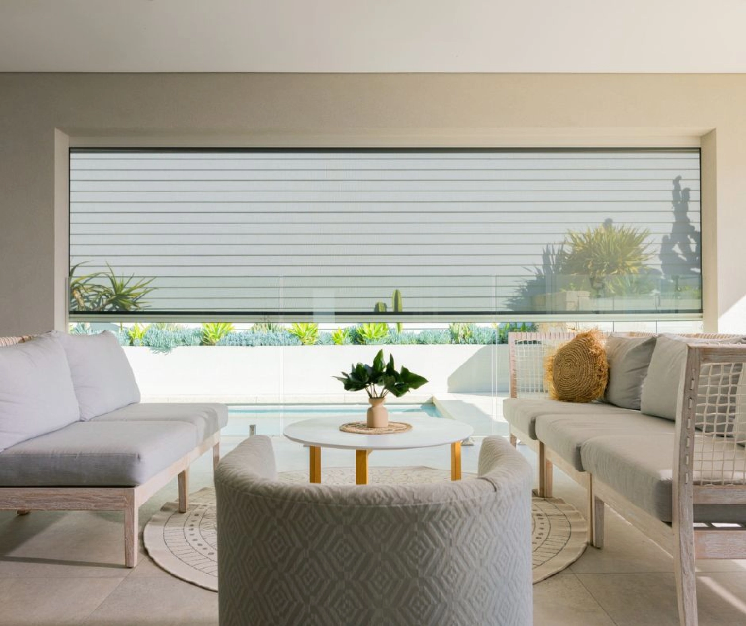 Outdoor blinds half raised in alfresco lounge area