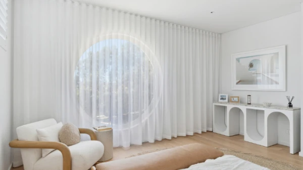 White sheer curtains closed across circular window overlooking Perth street