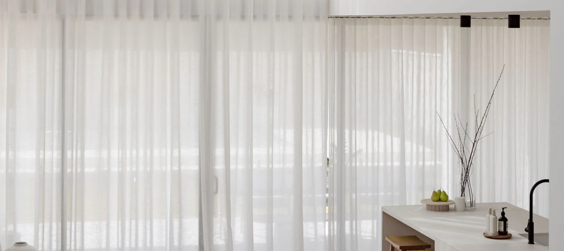 Interior view looking down on living room with sheer curtains over two floors.