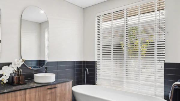 Venetian blinds in modern bathroom over bathtub